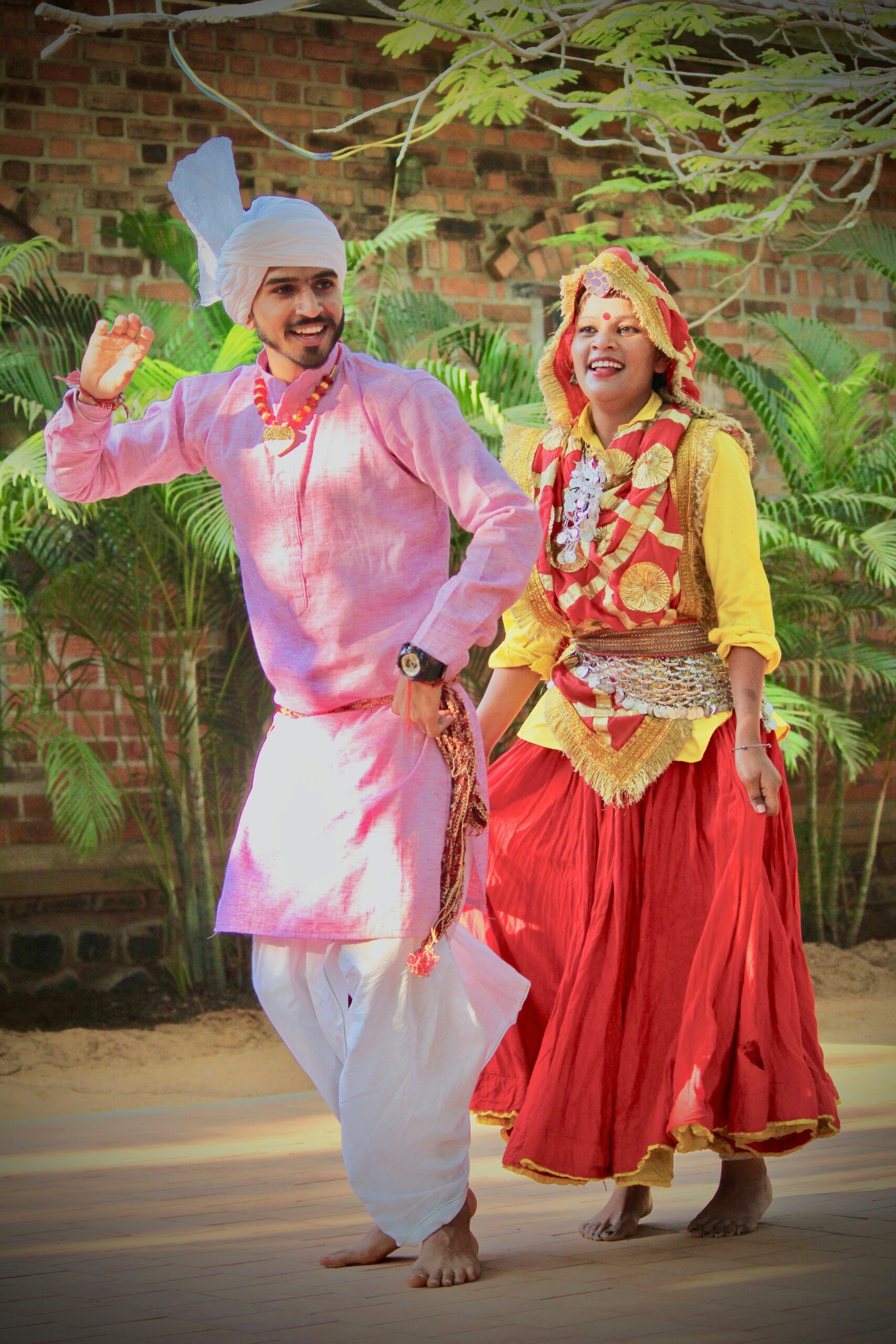 Couple dancing together in traditional folk style with bright cultural Indian costumes.